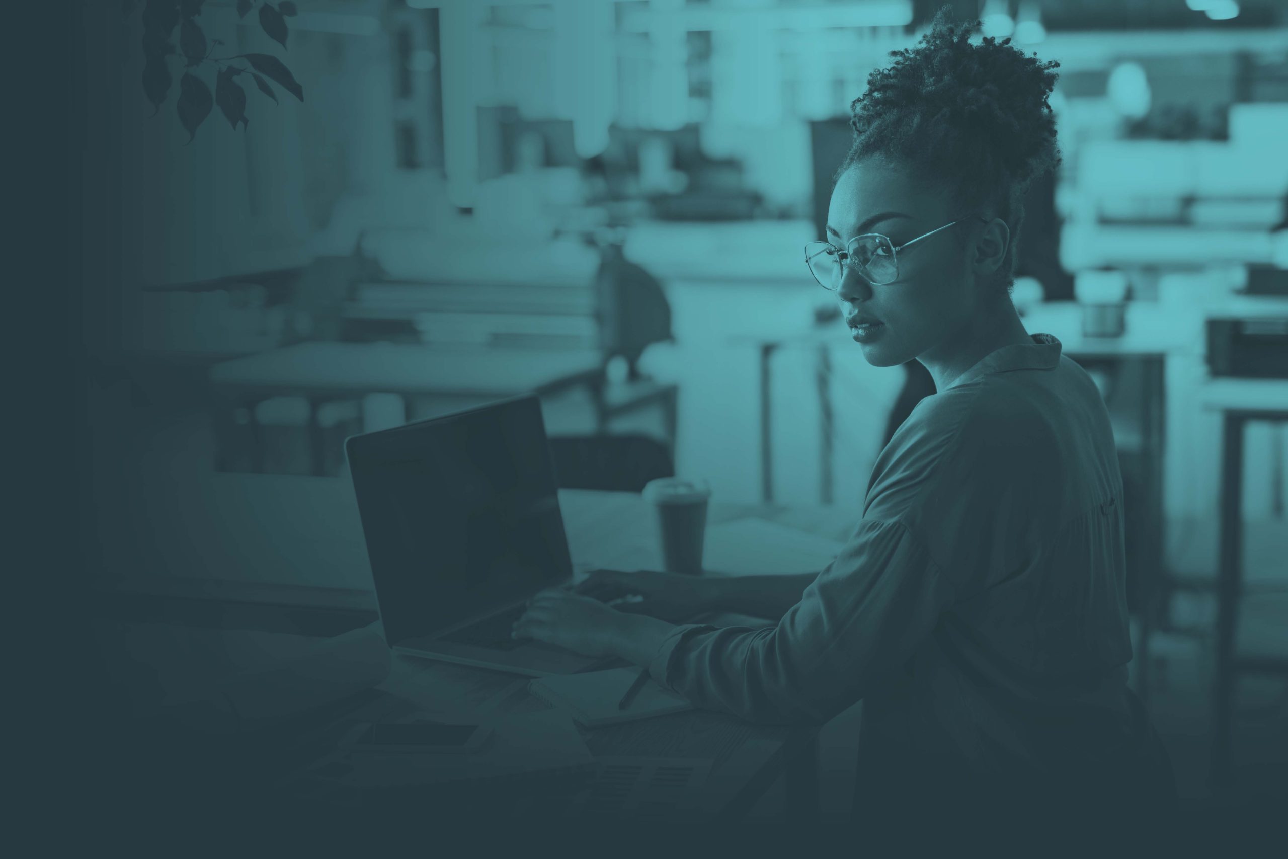 Young black woman typing on laptop while looking away