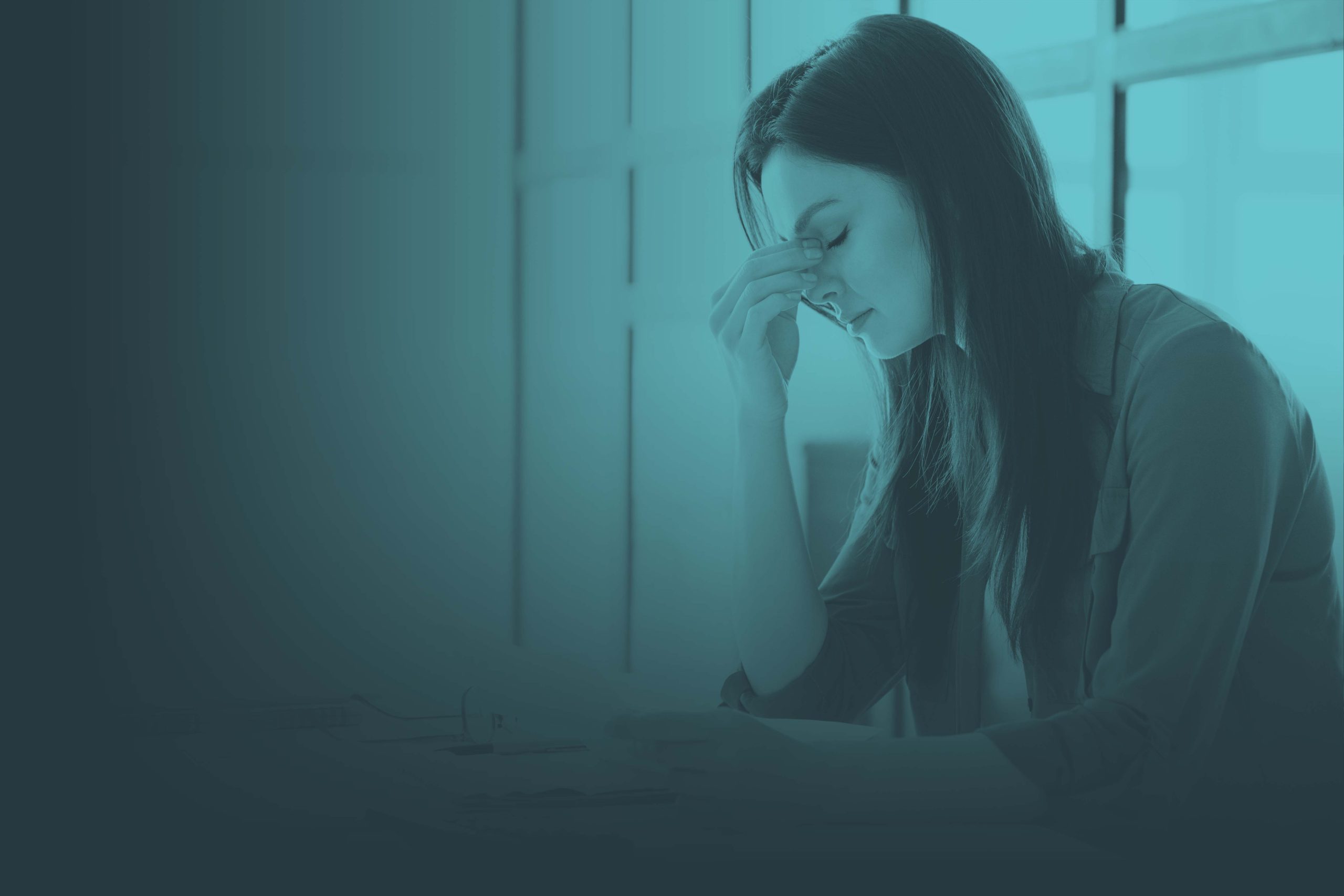 Stressed young woman holding hand to face