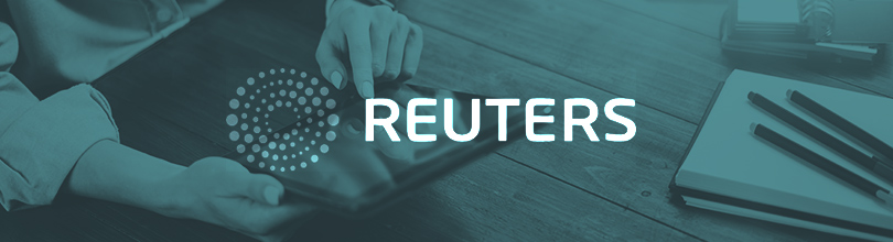 Reuters logo centered on partially transparent blue background over person working on tablet device