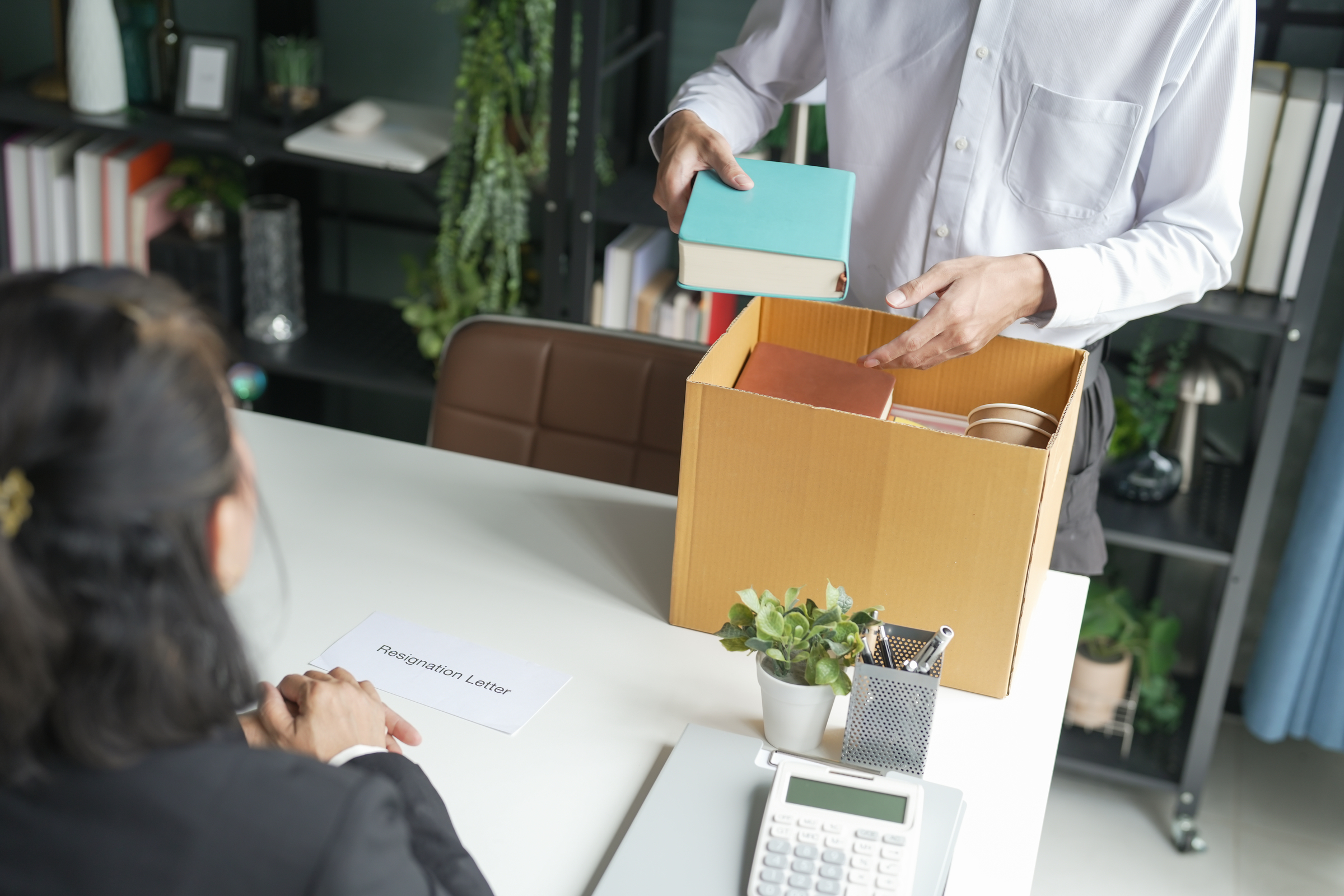 An employee affected by a large-scale reduction-in-force packs his belongings into a box.